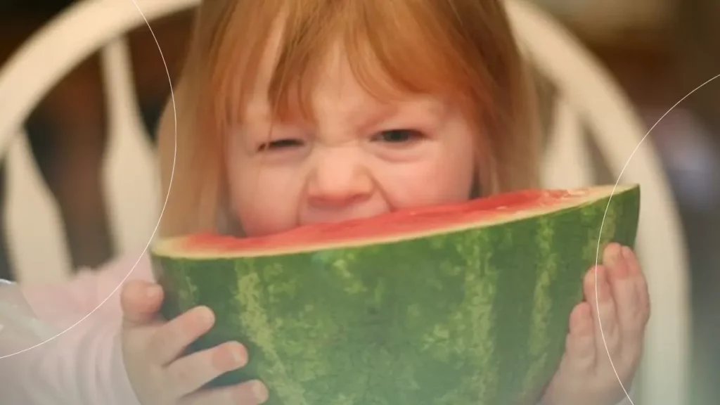 کودکی که با دندان های خود در حال خوردن هندوانه است