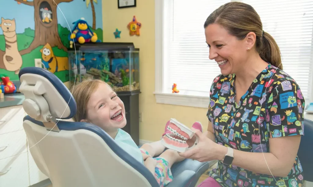 تصویر متخصص ارتودنسی کودکان در حال ویزیت بیمار